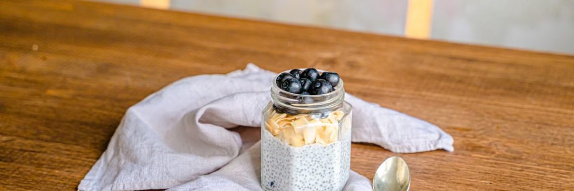 Healthy chia pudding with blueberries and coconut on a rustic wooden table. Perfect for breakfast.